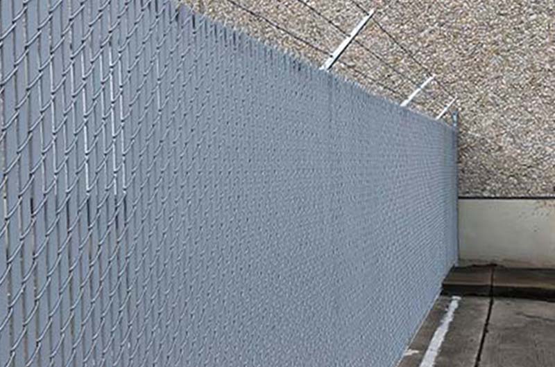 Commercial chain link privacy fence with warehouse