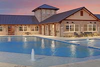 Sunset behind community center with pool and fountains