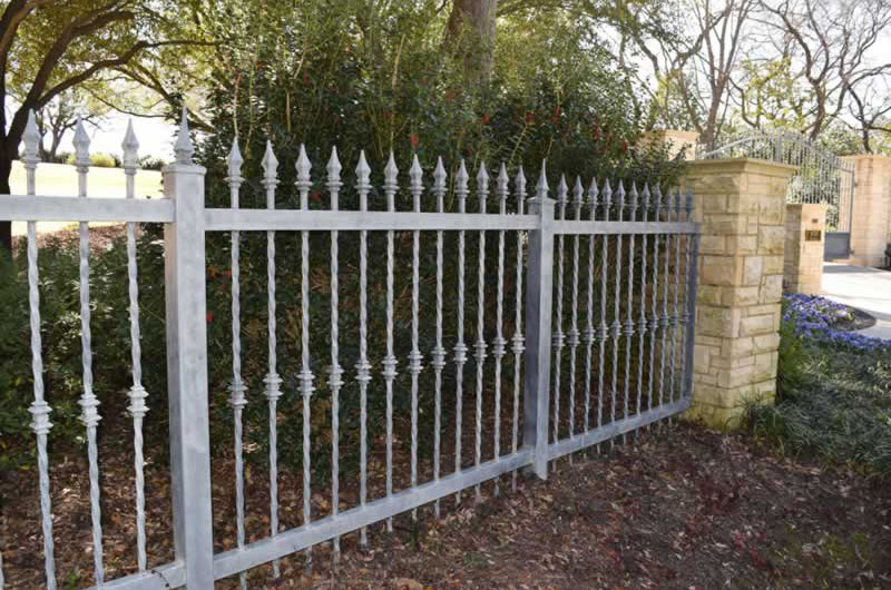 Residential gray metal fence with brick posts