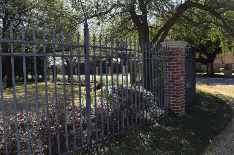 Residential gray metal fence with brick posts