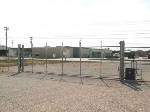 Industrial metal fence with gate operator at trucking entrance